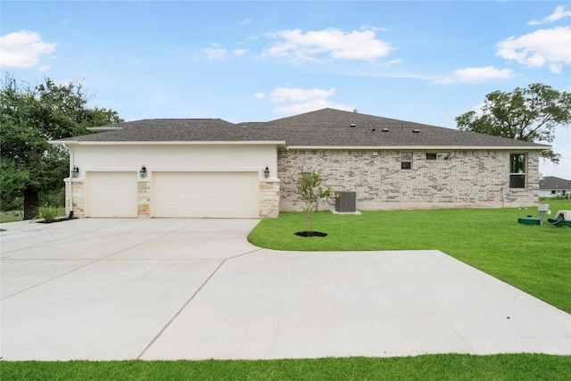 ranch-style house featuring a front yard, roof with shingles, driveway, and an attached garage