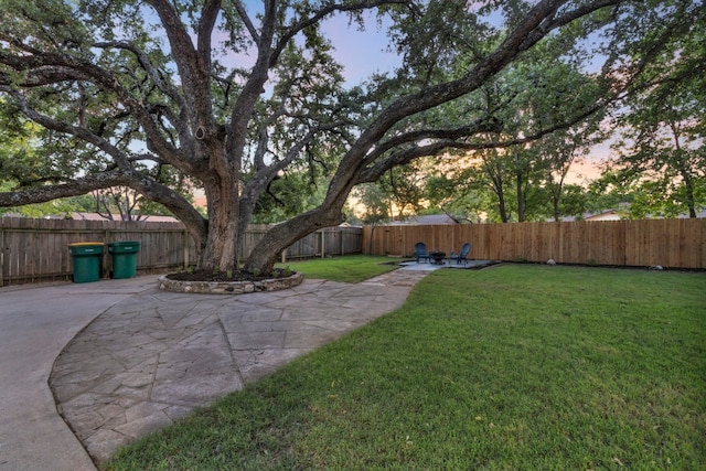 yard at dusk featuring a patio