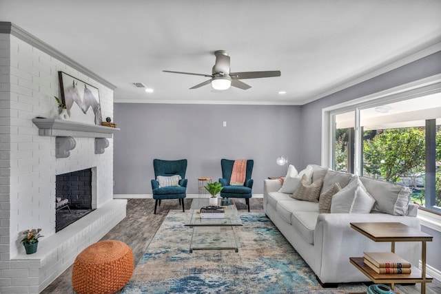 living room featuring brick wall, ceiling fan, crown molding, dark hardwood / wood-style flooring, and a fireplace