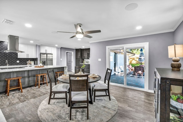 dining area with light hardwood / wood-style flooring, ceiling fan, and ornamental molding