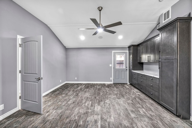 kitchen with light stone countertops, lofted ceiling, ceiling fan, dark brown cabinetry, and dark hardwood / wood-style flooring