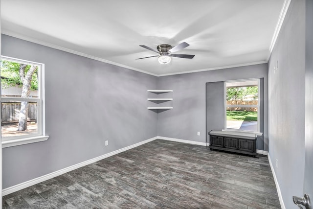 empty room with a healthy amount of sunlight, dark wood-type flooring, ceiling fan, and crown molding