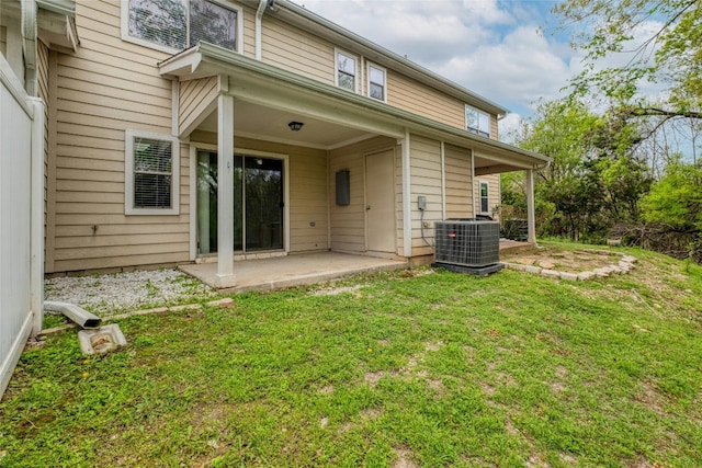 rear view of property featuring a yard, central AC unit, and a patio area