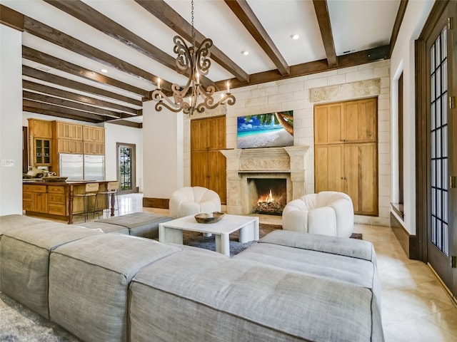 living room with a premium fireplace, a notable chandelier, and beamed ceiling