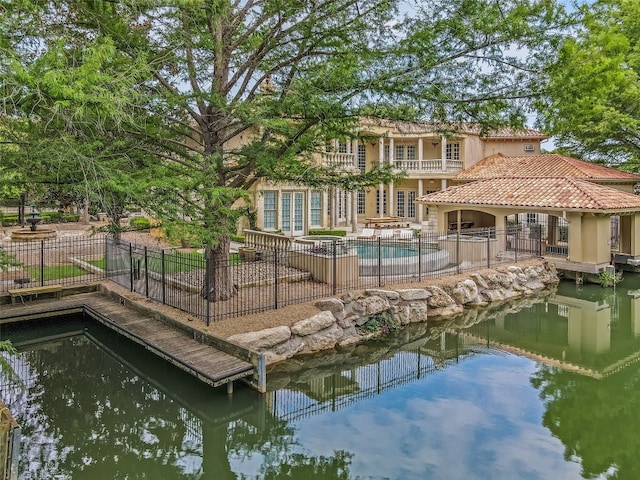 dock area with a balcony, a patio area, and a fenced in pool