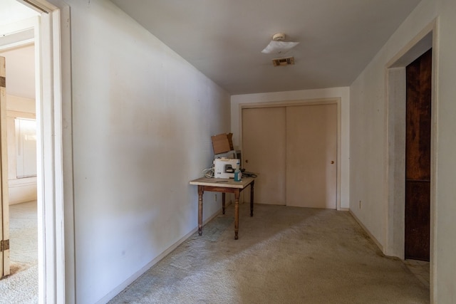 hallway featuring light colored carpet