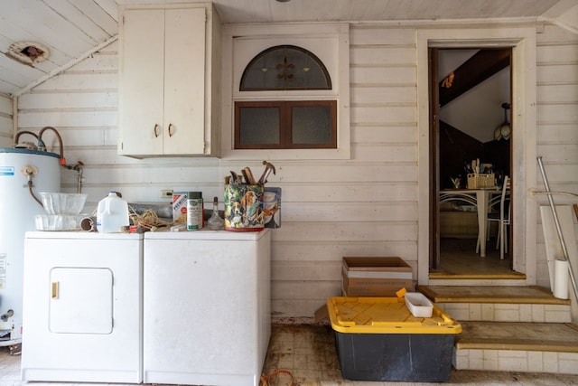 clothes washing area with wooden ceiling, water heater, wooden walls, and washer and dryer