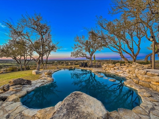 view of pool at dusk