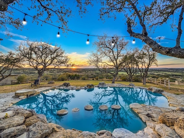 pool at dusk with a rural view