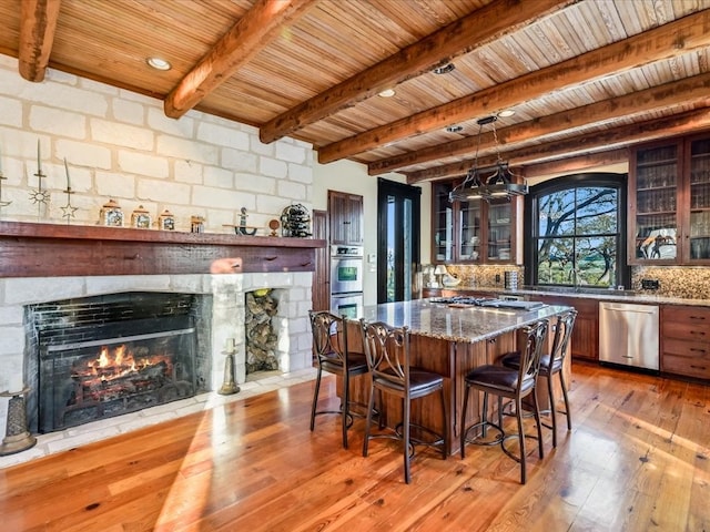 dining room with hardwood / wood-style floors, wooden ceiling, and beamed ceiling