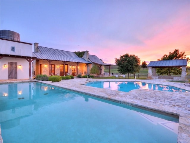 pool at dusk with a patio