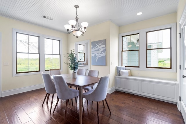 dining room with dark hardwood / wood-style flooring and an inviting chandelier