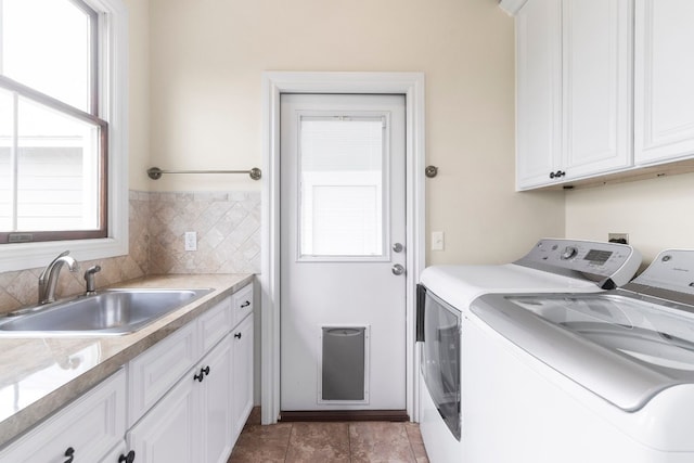 clothes washing area with sink, separate washer and dryer, and a wealth of natural light