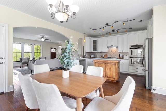 dining space with sink, crown molding, dark hardwood / wood-style floors, and ceiling fan with notable chandelier