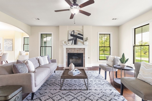 living room with ceiling fan, a tile fireplace, and hardwood / wood-style floors