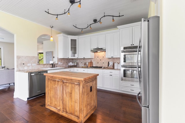 kitchen with appliances with stainless steel finishes, white cabinetry, and dark hardwood / wood-style flooring