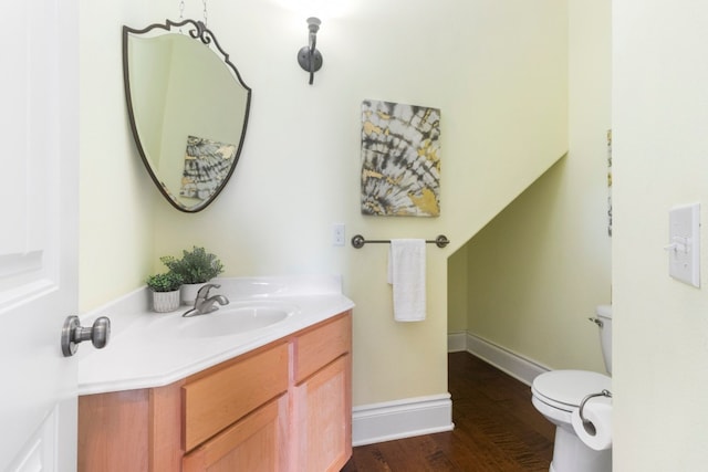 bathroom featuring toilet, hardwood / wood-style flooring, and vanity