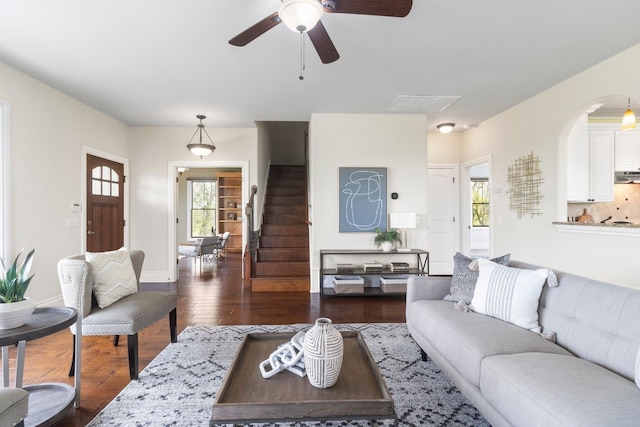 living room featuring dark wood-type flooring and ceiling fan