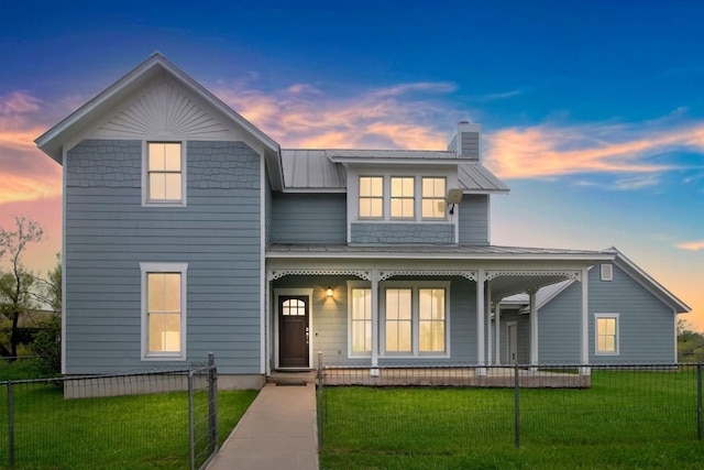 view of front of property featuring covered porch and a lawn