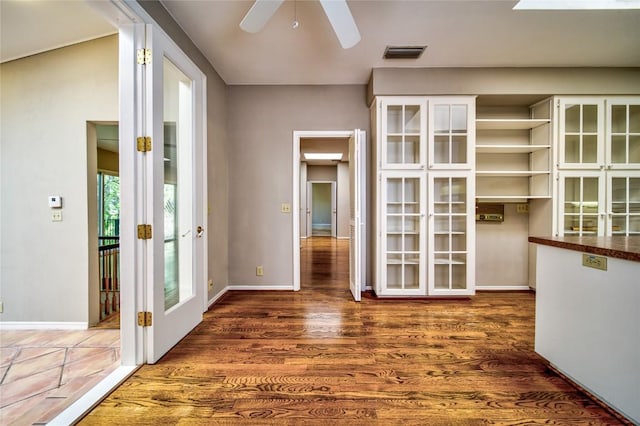 empty room with dark wood-type flooring, ceiling fan, and french doors