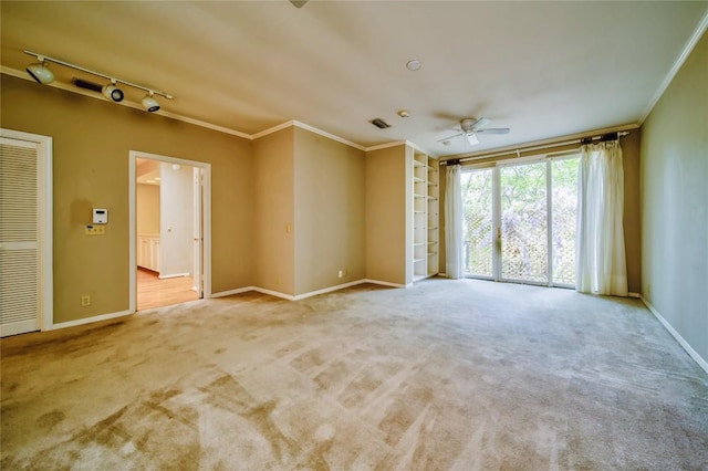 carpeted empty room featuring crown molding, track lighting, and ceiling fan