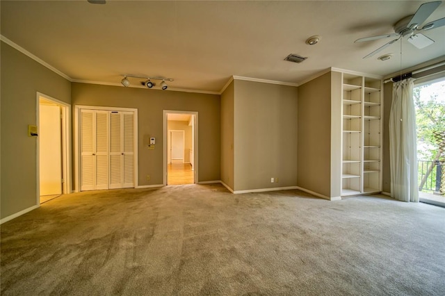 carpeted spare room featuring ceiling fan, track lighting, and ornamental molding