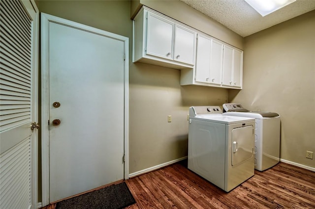 washroom featuring cabinets, dark hardwood / wood-style flooring, washer and clothes dryer, and a textured ceiling