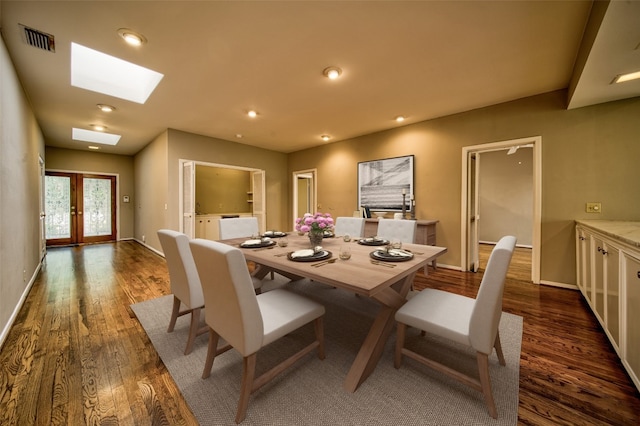 dining room featuring a skylight, dark wood-type flooring, and french doors