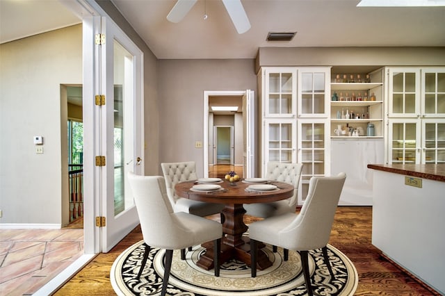 dining space featuring ceiling fan, dark hardwood / wood-style flooring, and french doors