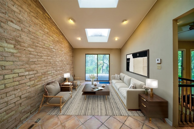 tiled living room featuring vaulted ceiling with skylight and brick wall