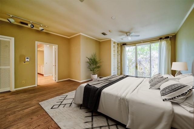 bedroom with hardwood / wood-style flooring, ceiling fan, crown molding, and rail lighting