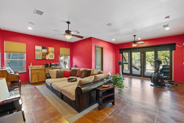 tiled living room with ceiling fan, a wealth of natural light, and french doors