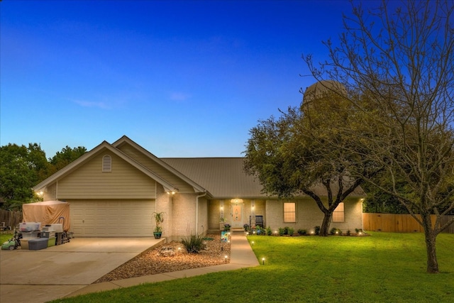 ranch-style home featuring a garage and a yard