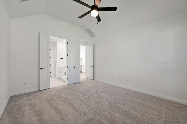 unfurnished bedroom with lofted ceiling, ensuite bathroom, ceiling fan, and light colored carpet