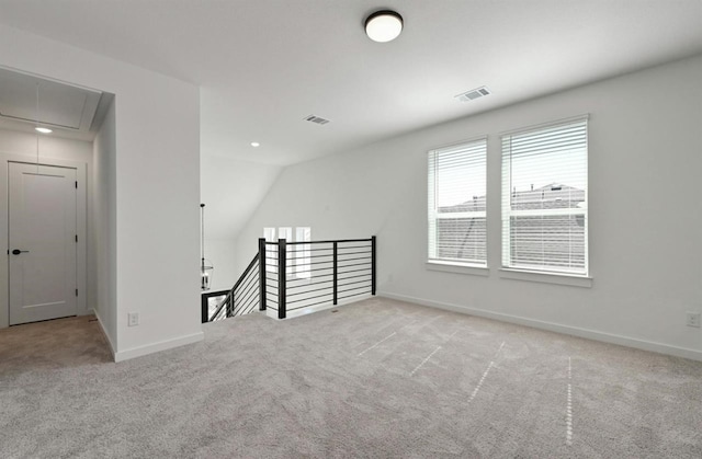 carpeted spare room featuring lofted ceiling