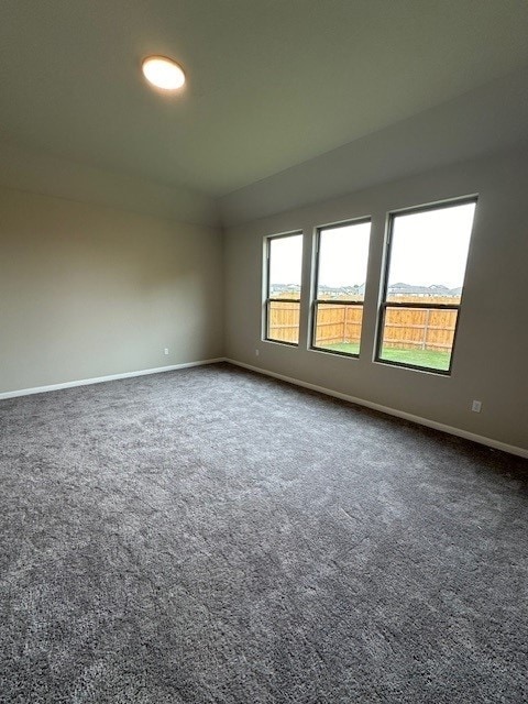 spare room with dark carpet