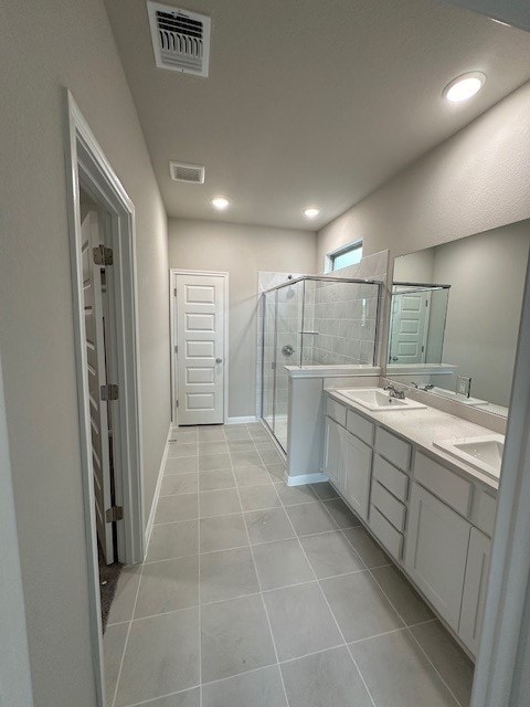 bathroom featuring an enclosed shower, vanity, and tile patterned flooring