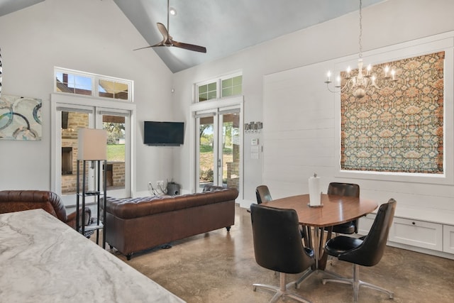 dining room featuring high vaulted ceiling, french doors, ceiling fan with notable chandelier, and concrete flooring