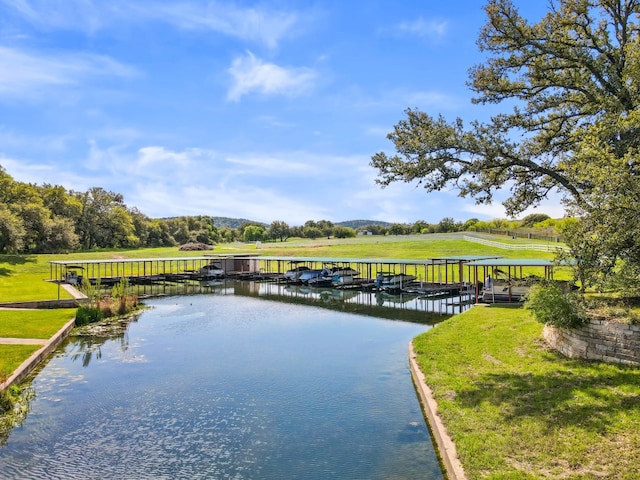 view of dock featuring a water view and a yard