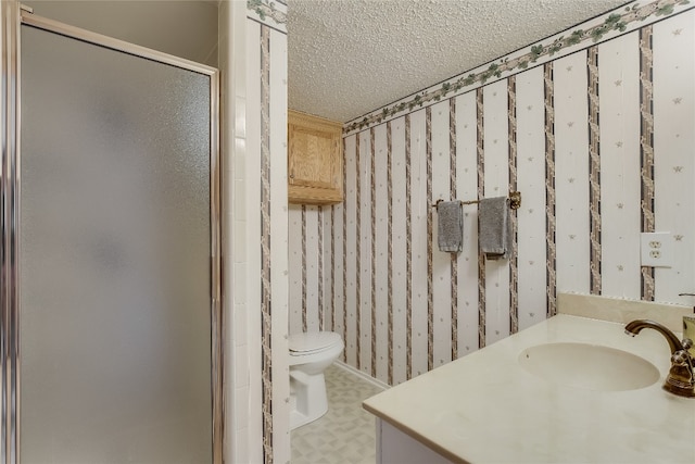 bathroom with vanity, a shower with shower door, a textured ceiling, and toilet