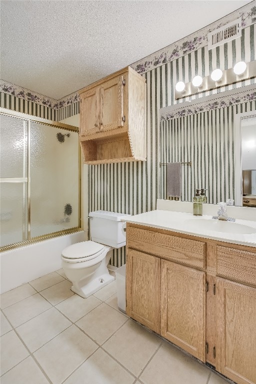 full bathroom with vanity, tile patterned floors, toilet, enclosed tub / shower combo, and a textured ceiling