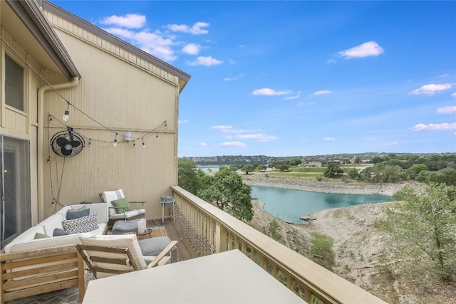 balcony with an outdoor living space and a water view