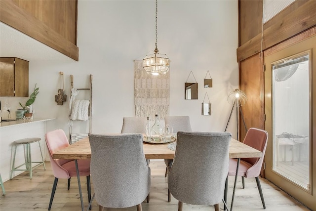 dining space featuring light hardwood / wood-style flooring and a notable chandelier