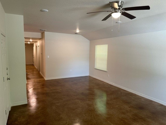 empty room featuring a textured ceiling, ceiling fan, and lofted ceiling