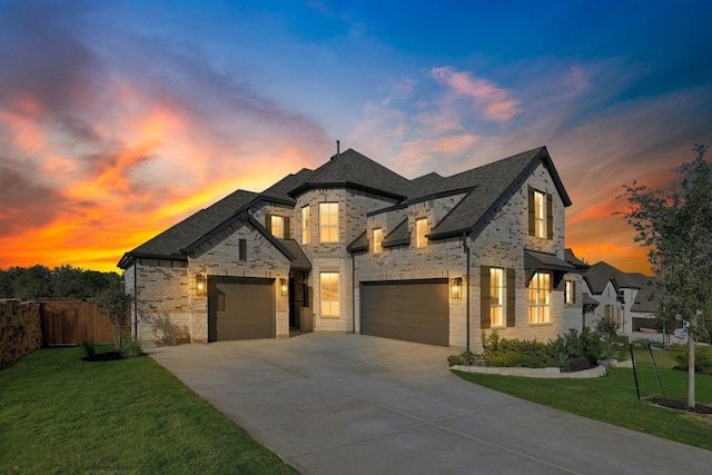 french provincial home featuring a garage and a lawn