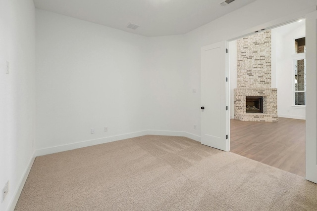 unfurnished room featuring light wood-type flooring and a fireplace