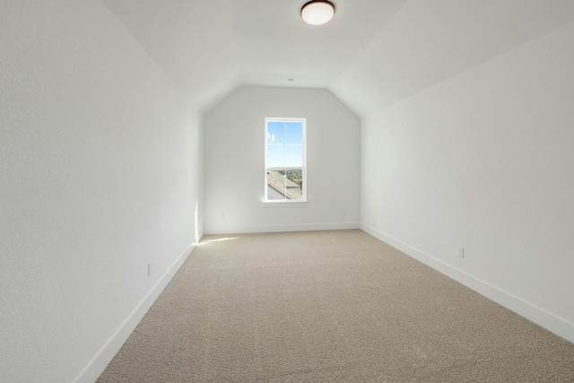 additional living space with vaulted ceiling and light colored carpet