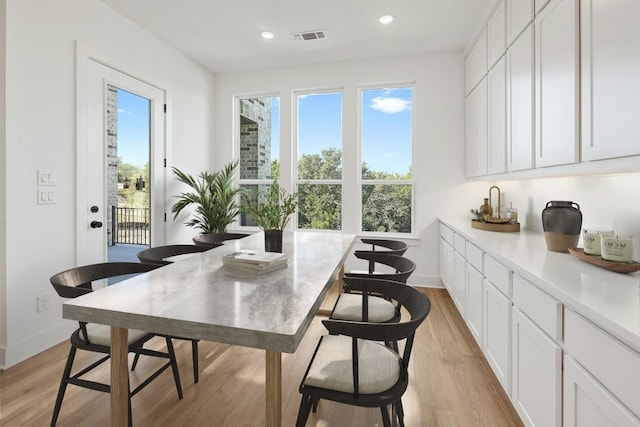 dining area featuring light wood-type flooring and a healthy amount of sunlight