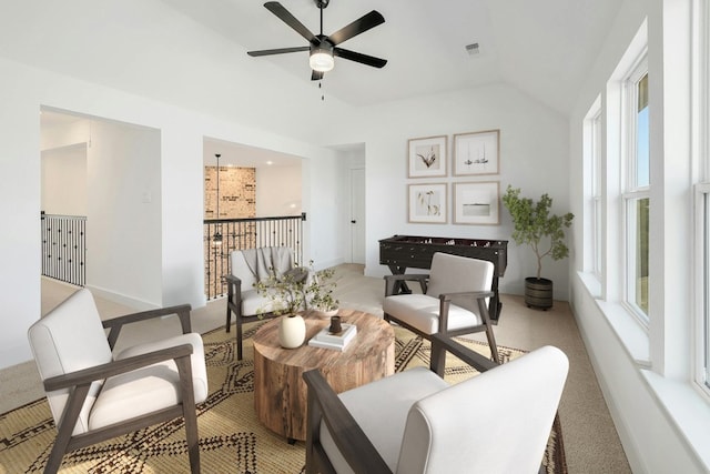 carpeted living room with ceiling fan and vaulted ceiling