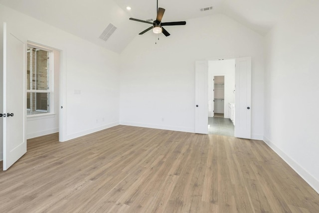 spare room with light hardwood / wood-style floors, high vaulted ceiling, and ceiling fan